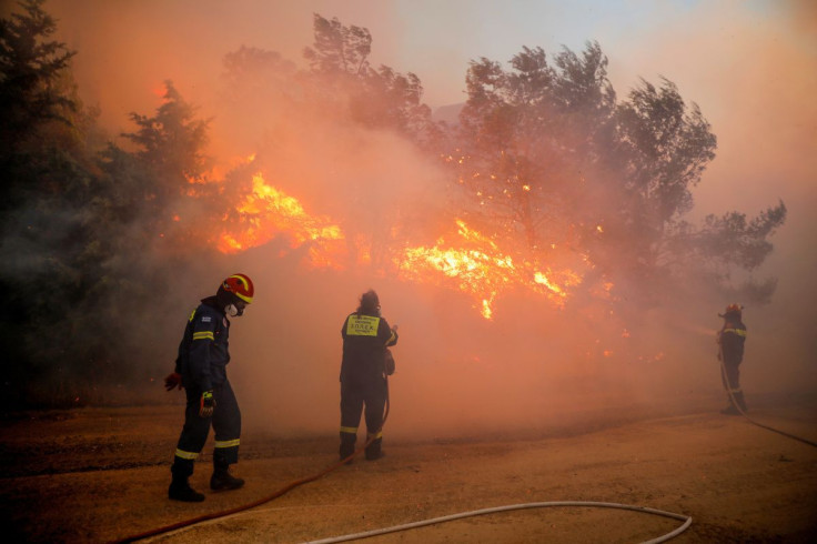 Firefighters try to extinguish a wildfire burning in Ntrafi, Athens, Greece, July 19, 2022.