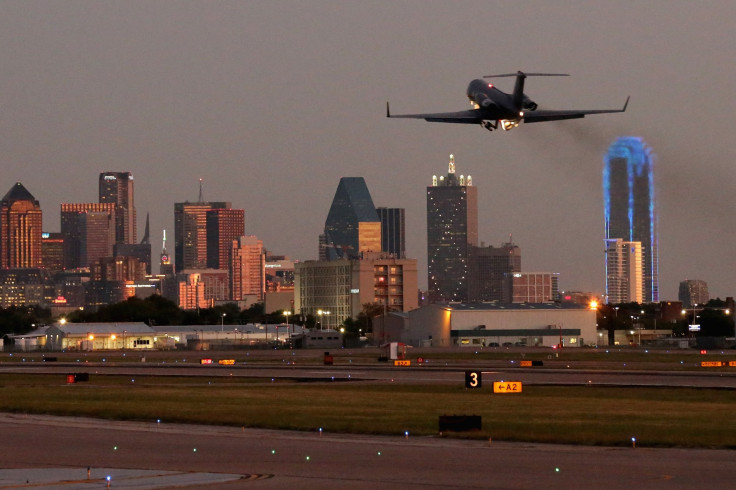 An airplane takes off from Dallas Love Field airport, with downtown Dallas in the background, Oct. 16, 2014.