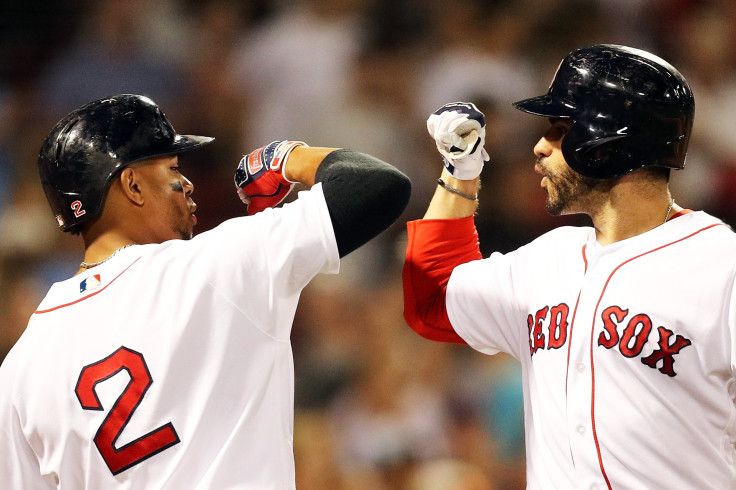 J.D. Martinez #28 high fives Xander Bogaerts #2 of the Boston Red Sox after hitting a three-run home run in the eighth inning of a game against the Texas Rangers at Fenway Park on July 9, 2018 in Boston.
