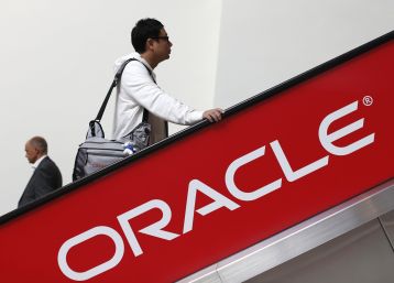 Oracle is reportedly planning to layoff thousands of employees. In photo: two attendees ride an escalator during Oracle OpenWorld 2012 in San Francisco, California October 1, 2012.