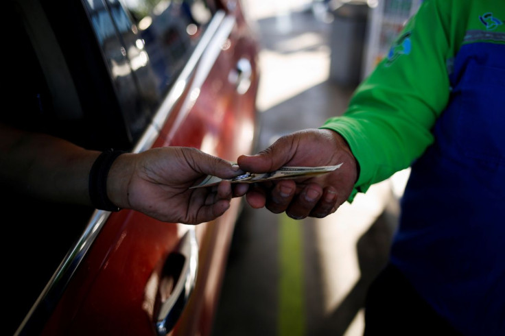 A Texan resident pays after filling his car with gasoline at a gas station following increased fuel prices in U.S., in Ciudad Juarez, Mexico April 4, 2022.