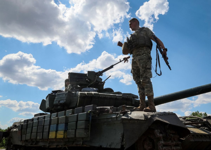 A Ukrainian serviceman stands on a tank loaded at a military truck, amid Russia's invasion of Ukraine, in the Donbas region, Ukraine July 12, 2022.