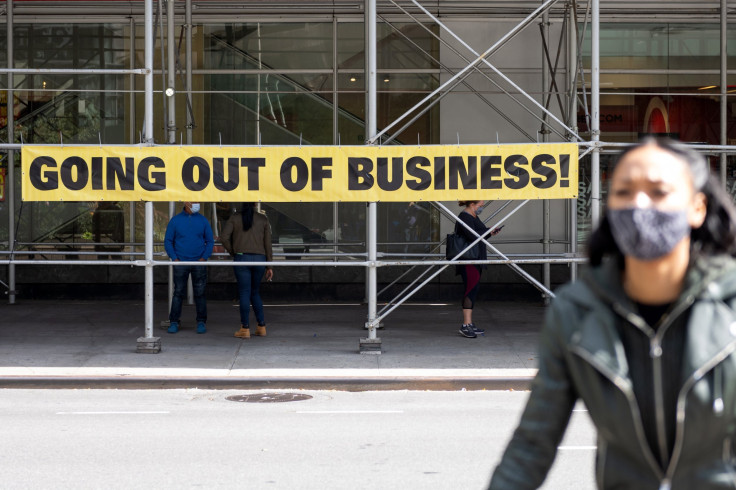 More retailers are announcing plans to liquidate their companies amid the COVID-19 pandemic. A woman is pictured walking past a Going Out of Business sign in New York City on Sept. 20, 2020.