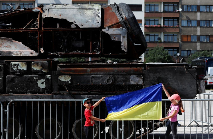 Children hold up a Ukrainian flag near Russian military equipment destroyed by the Armed Forces of Ukraine displayed, as Russia's attack on Ukraine continues, in Prague, Czech Republic, July 11, 2022.