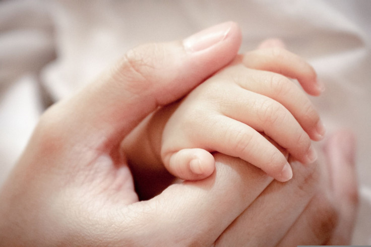 Representation. A person holding a baby's hand.