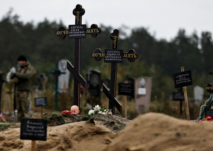 A doll is seen among graves which Ukrainian officials say is a civilian mass grave, in the newly recaptured town of Lyman
