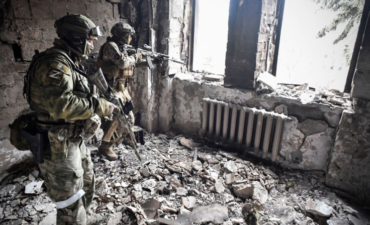 Two Russian soldiers patrol in the Mariupol drama theatre, bombed last March 16, in Mariupol on April 12, 2022