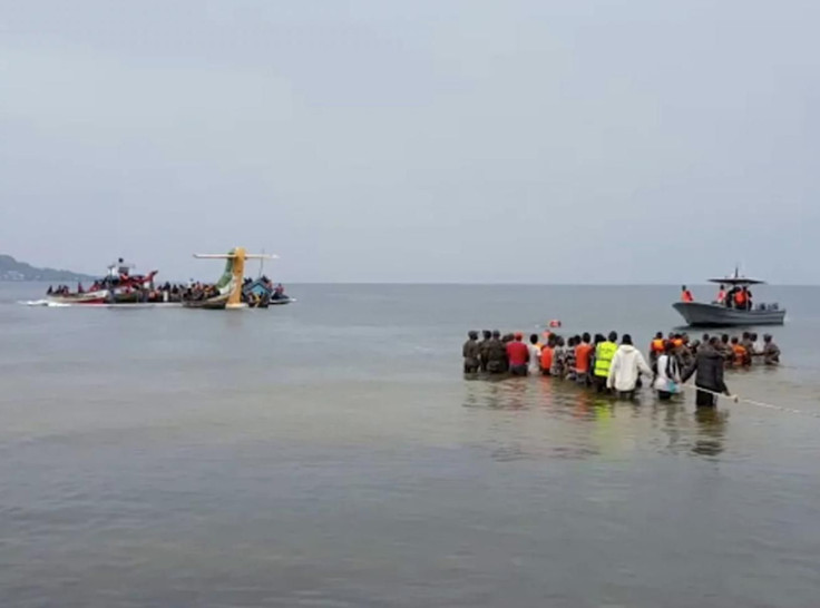 Rescuers in boats and standing in the water are seen around the tail fin of a crashed Precision Air passenger aircraft on the shores of Lake Victoria in Bukoba, in western Tanzania on Sunday.