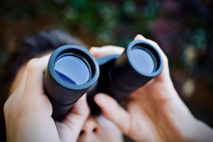 Representations. A man looking at the sky with binoculars.