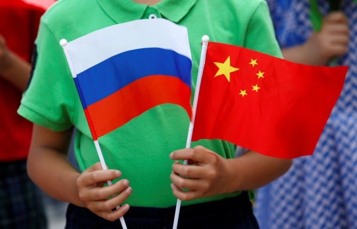 Representation. A child holds the national flags of Russia and China.