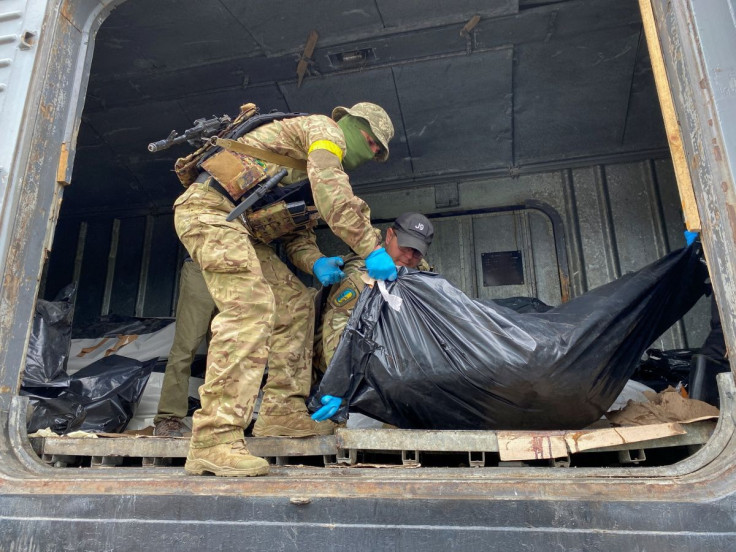 Ukrainian servicemen load bodies of killed Russian soldiers to a refrigerated rail car, as Russia's attack on Ukraine continues, at a compound of a morgue in Kharkiv, Ukraine
