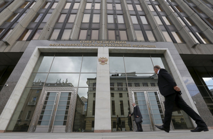 Men walk past the Federation Council, head of Russia's upper house of parliament, in Moscow, Sept. 30, 2015. The Federation Council voted unanimously to give President Vladimir Putin approval to deploy the country's military in Syria, Sergei Ivanov, the h