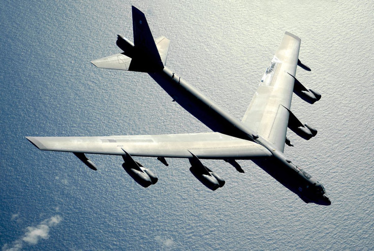 A B-52H long-range bomber flies over the ocean.