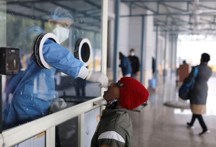 A healthcare worker collects a test swab sample from a child amidst the spread of the coronavirus disease (COVID-19), at a testing centre inside a hospital in New Delhi, India, January 14, 2022.
