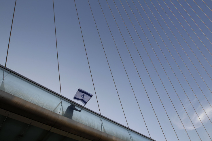 A right-wing demonstrator holds an Israeli flag as he walks to a protest in support of Israel at the entrance to Jerusalem on June 1, 2010.