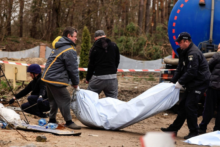 Ukrainian policemen carrying the body of civilians who were killed by Russian soldiers