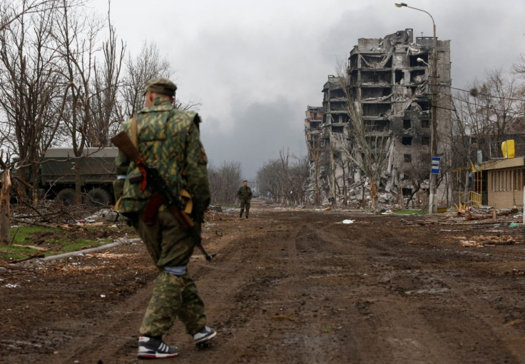 Service members of pro-Russian troops walk in the street during fighting in Ukraine-Russia conflict near a plant of Azovstal Iron and Steel Works company in the southern port city of Mariupol, Ukraine April 12, 2022.