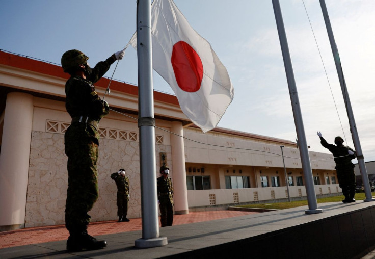 Members of the Japan Ground Self-Defense Force (JGSDF) bring down the Japanese national flag in the early evening, at JGSDF Miyako camp on Miyako Island, Okinawa prefecture, Japan April 20, 2022.