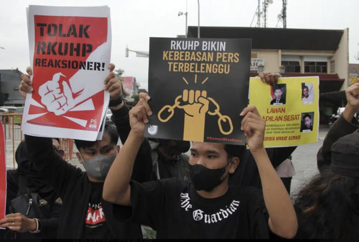 Activists hold up posters during a rally against Indonesia's new criminal law in Yogyakarta, Indonesia, Tuesday, Dec. 6, 2022. The country's parliament passed the long-awaited and controversial revision of its penal code Tuesday that criminalizes extramar