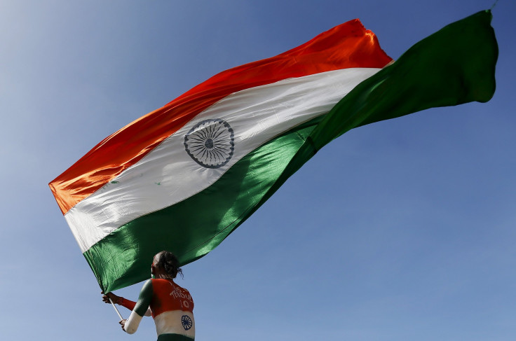 A supporter of the Indian cricket team waves the Indian national flag during the second day of the first test cricket match between India and Sri Lanka in Galle, Sri Lanka, Aug. 13, 2015.