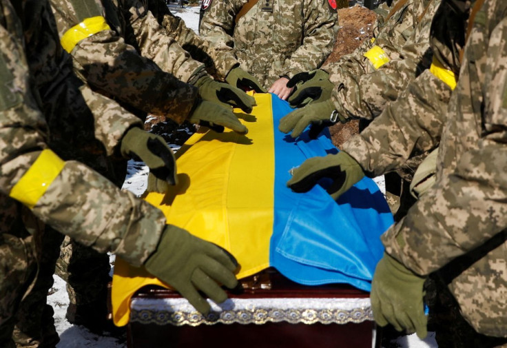 Members of the Honour Guard place the national flag to a coffin with a body of the member of the Ukrainian Armed Forces, Valerii, who was killed during Russia's invasion of Ukraine, during a funeral ceremony in Kyiv, Ukraine, March 8, 2022.