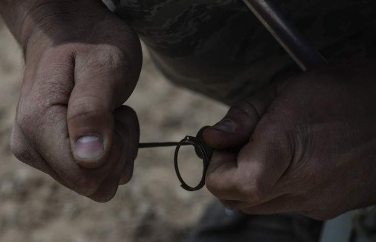 Senior Airman Kyle Osgood, 99th Civil Engineer Squadron explosive ordinance technician, pulls the pin on an explosive during a training exercise at Nellis Air Force Base, Nev., May 5, 2016.