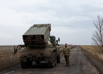 A Ukrainian serviceman of a fire platoon waits for order to fire a rocket from an MLRS, near the frontline, in Donetsk region