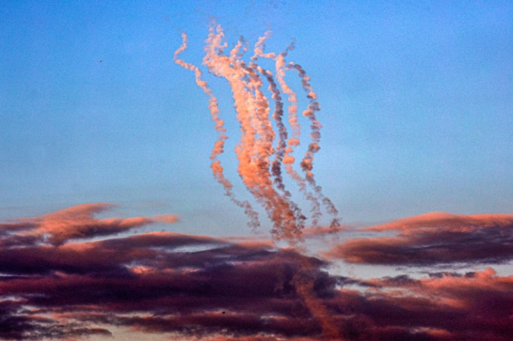 Smoke plumes trail from a salvo of rockets fired towards Israel, pictured from the southern Gaza Strip
