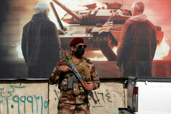 A paramilitary of the Hashed al-Shaabi (Popular Mobilisation) stands guard during the funeral in Baghdad of a fellow fighter killed in American air strikes targeting Iran-backed groups
