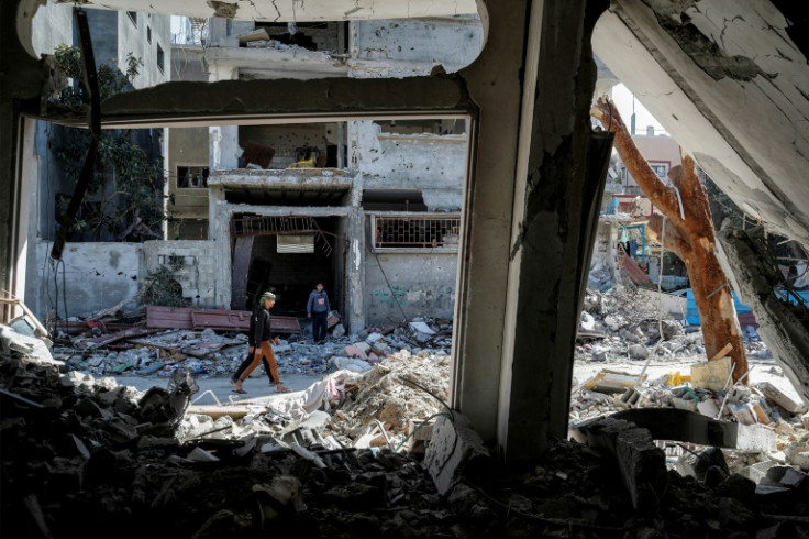 A man walks past the rubble of a destroyed building in the Maghazi camp for Palestinian refugees, which was severely damaged by Israeli bombardment amid the ongoing conflict in the Gaza Strip between Israel and the Palestinian militant group Hamas
