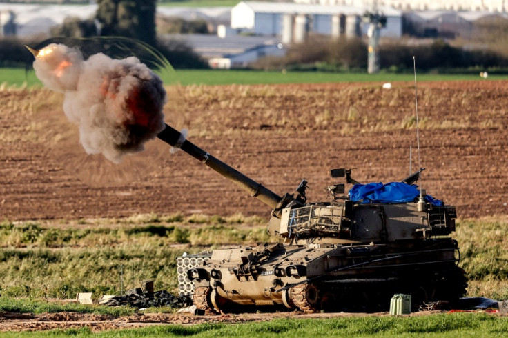A shock wave is seen as a projectile exits the barrel of an Israeli army self-propelled artillery Howitzer firing rounds from southern Israel toward the Gaza Strip