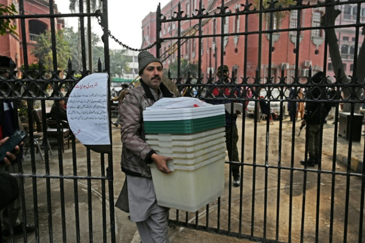 A presiding officer collecting election material from a distribution centre in Lahore on the eve of the vote