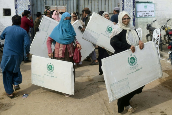 Pakistan election workers collect voting materials at a distribution center in Karachi on Wednesday