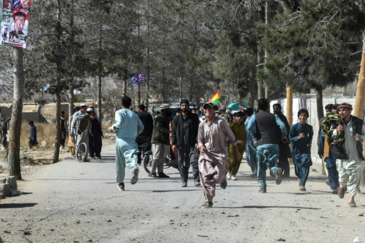 People run out of a polling station in Quetta, reportedly after a hand grenade attack during Pakistan's national elections