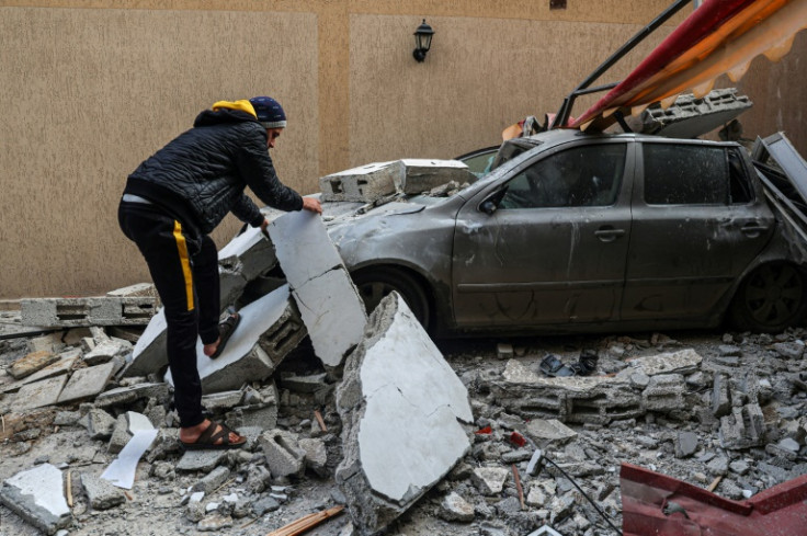 A Palestinian clears away debris in the aftermath of Israeli bombardment of Rafah