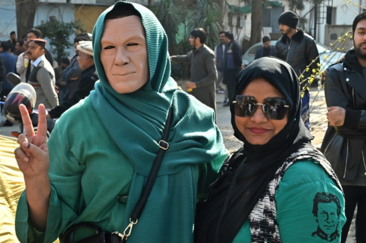 A supporter of the Pakistan Tehreek-e-Insaf (PTI) party wears an Imran Khan mask at a protest in Islamabad