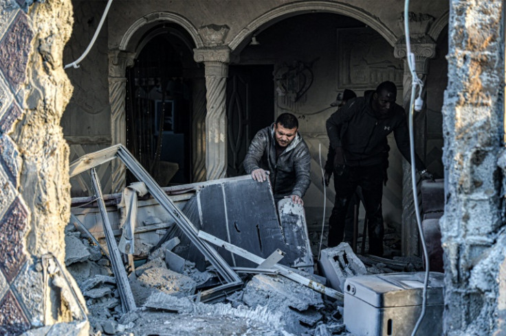 People sift through the rubble of a building damaged in an Israeli air strike on Rafah