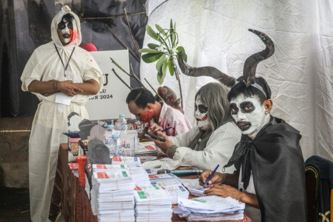 Staff members wearing horror themed costumes work at a polling station during Indonesia’s presidential and legislative elections in Surabaya
