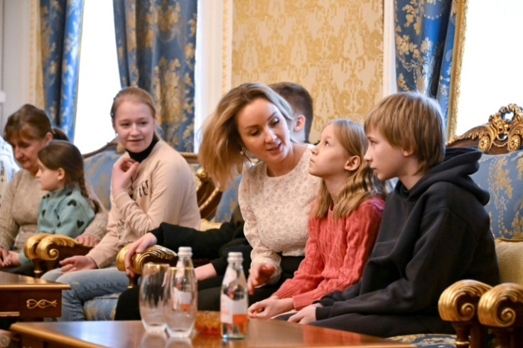 Russia's presidential commissioner for children's rights Maria Lvova-Belova talks with Ukrainian children before they return home under a deal brokered by Qatar