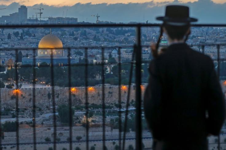 An ultra-Orthodox Jew looks from a spot on the Mount of Olives towards Jerusalem's Old City, with a view of the Dome of the Rock in the Al-Aqsa mosque compound