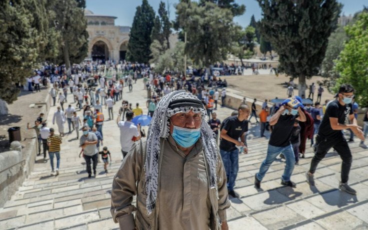 Palestinians leave after performing the Friday prayer outside the Dome of the Rock mosque