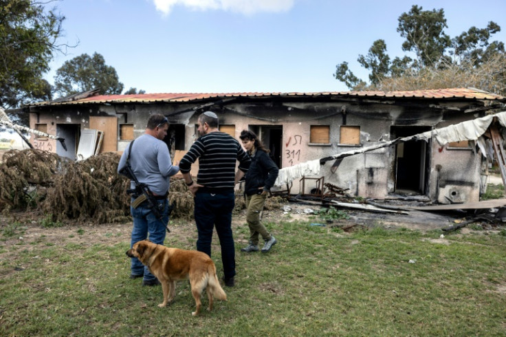 Israelis inspect a damaged house in Kibbutz Nirim following the deadly October 7 attack