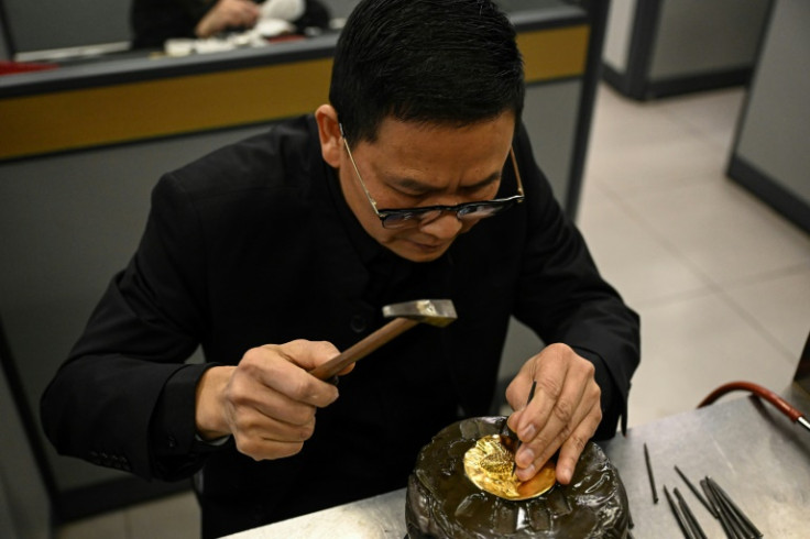 A jewellery craftsman works on a gold piece at the Chow Tai Fook master studio in Foshan, in southern China's Guangdong province