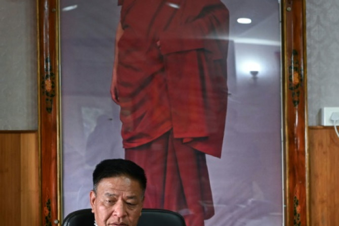 Penpa Tsering said he expects Tibetan spiritual leader the Dalai Lama, whose portrait looms behind him, to live decades longer