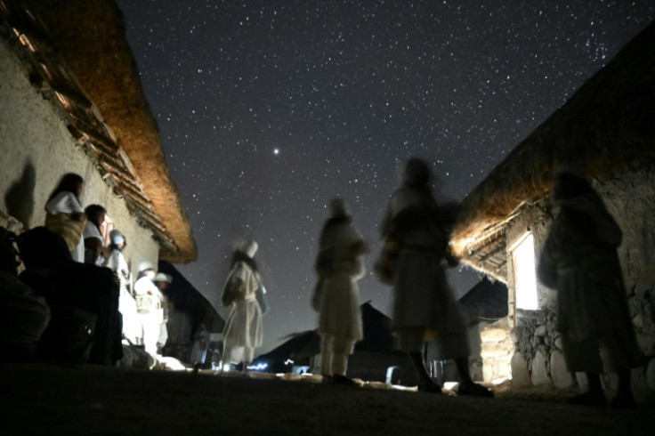 While they maintain their traditional clothing and beliefs, the Arhuaco carry cellphones in their woven bags, and use solar panels to electrify their mud huts