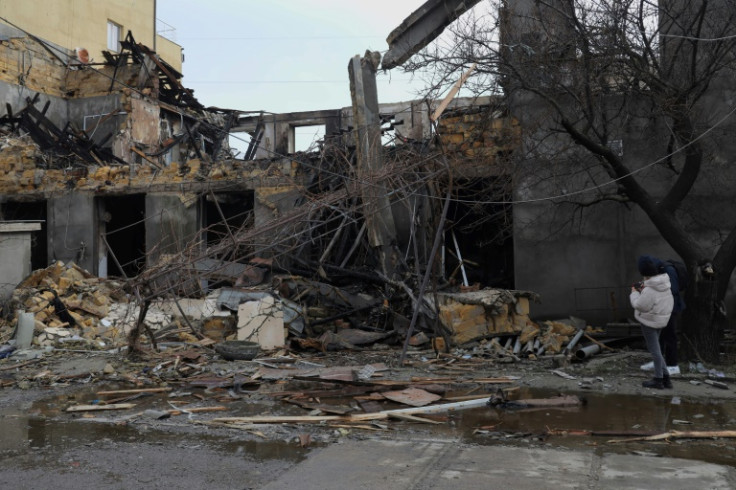 A woman stands next to a garment factory  destroyed in a drone attack in Odesa