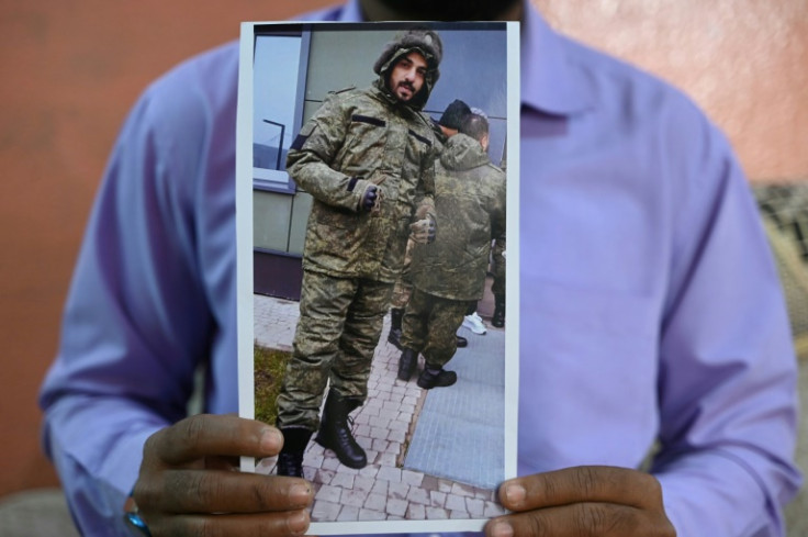 A photo of Indian national Mohammed Asfan in Russian military fatigues is held by his brother Mohammed Imran in HyderabadMohammed Imran shows his brother Mohammed Asfan photo who is stranded in Russia along the war torn Ukraine border, at their home