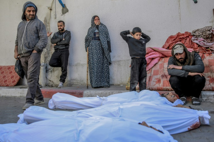 People at Al-Shifa hospital in Gaza City mourn over the bodies of Palestinians killed when people rushed toward aid trucks