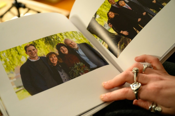 Danielle Gershkovich, sister of detained journalist Evan Gershkovich, holds open a photo of her brother and parents in her wedding album