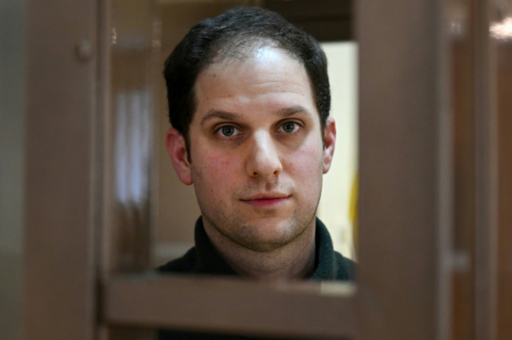 US journalist Evan Gershkovich, arrested on espionage charges, looks out from inside a defendant's at Moscow city court in February 2024